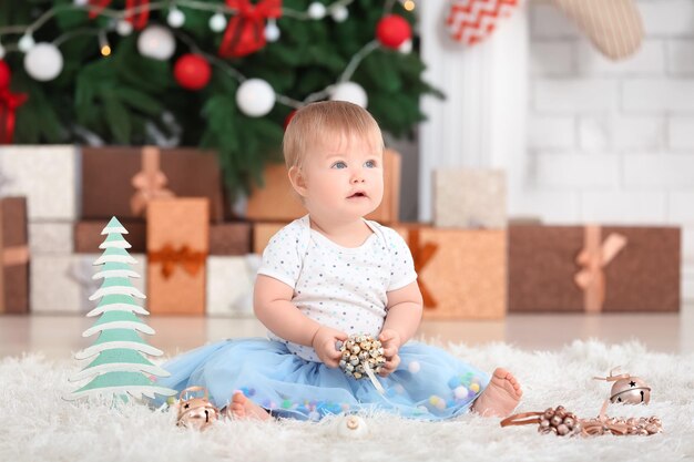 Bebê adorável no quarto decorado para o natal