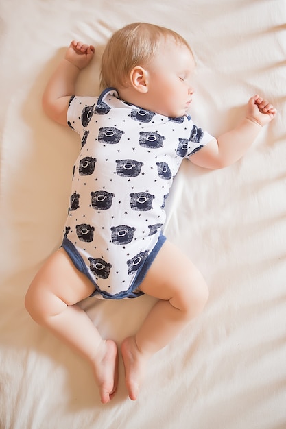 Bebê adorável tranquilo dormindo em sua cama em um quarto. Foco suave. Conceito de bebê dormindo. bebê de um ano dorme em casa