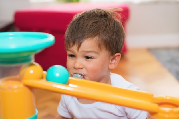 Bebé alegre que juega en el cuarto de niños