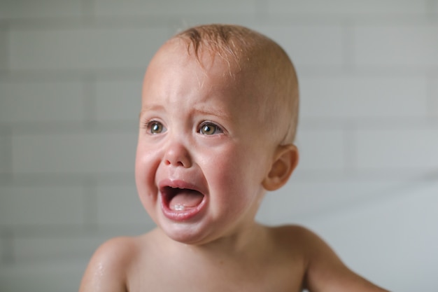 Bebé de un año de edad llora de cerca en el baño.