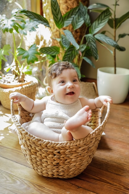 Bebé de un año sonriendo y posando dentro de una canasta