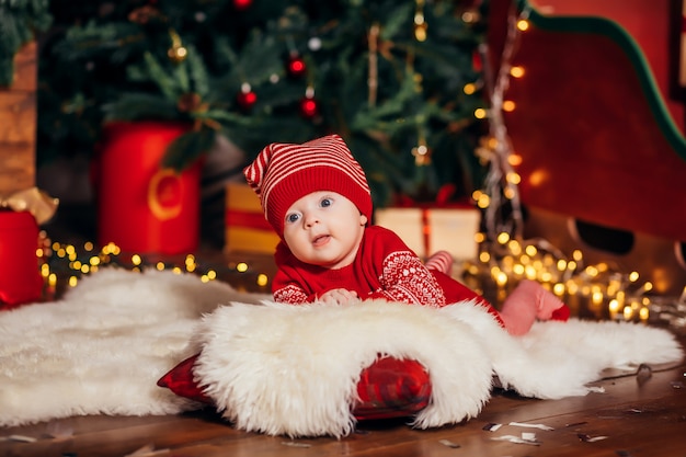 Bebê ao lado da árvore de Natal