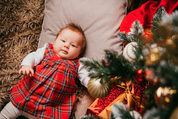 Foto bebê ao lado da árvore de natal