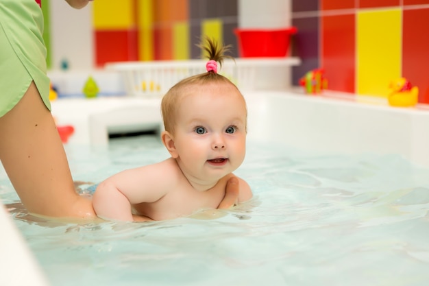 Bebé aprende a nadar, natación infantil, madre de familia saludable enseñando piscina para bebés