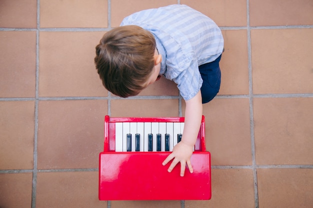 Bebé aprendiendo a tocar música en casa con un piano para niños.