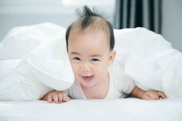 Bebé asiático acostado en la cama con una manta suave en el interior lindo bebé recién nacido asiático