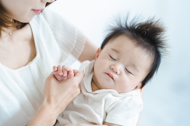 Bebé asiático al que abrazar en una habitación luminosa