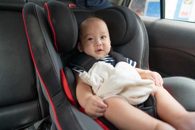 Bebé asiático en asiento de coche