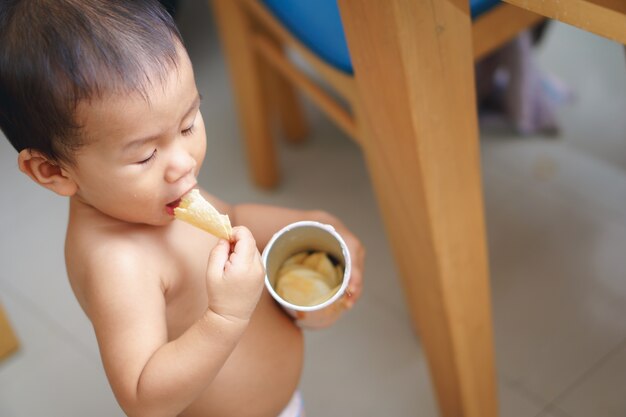 Bebé asiático comiendo papas fritas