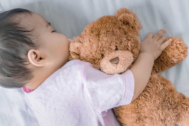 Bebé asiático durmiendo en la cama