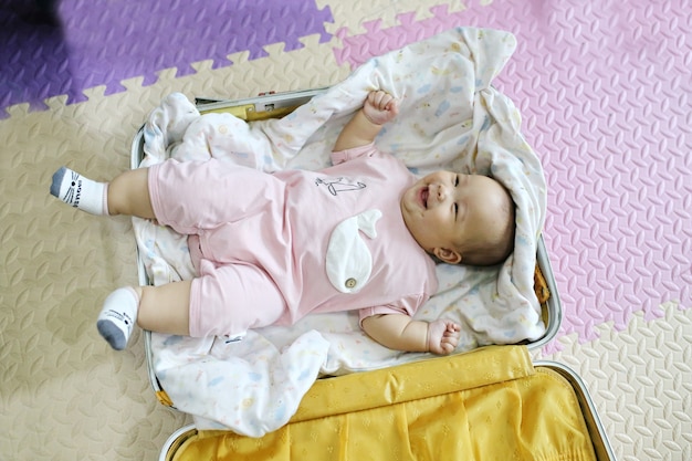 Bebé asiático que pone en el bolso para dormir en el aeropuerto