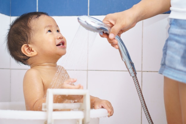 Bebê asiático tomar um banho por sua mãe