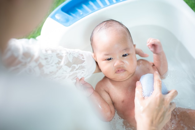 un bebé bañándose con la madre