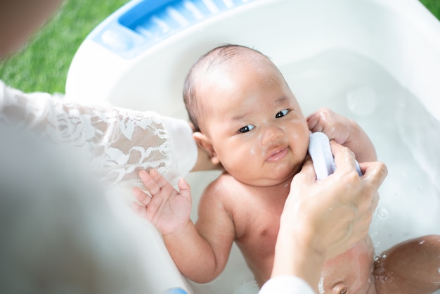 un bebé bañándose con la madre