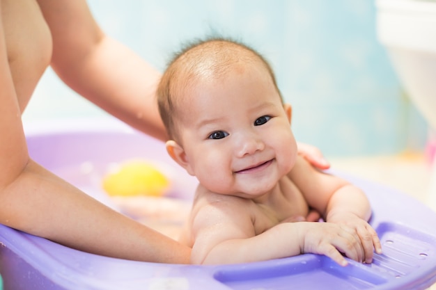 bebé bañándose con su madre en el baño