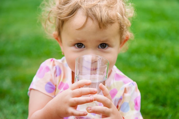 Bebé bebe agua de un vaso Enfoque selectivo
