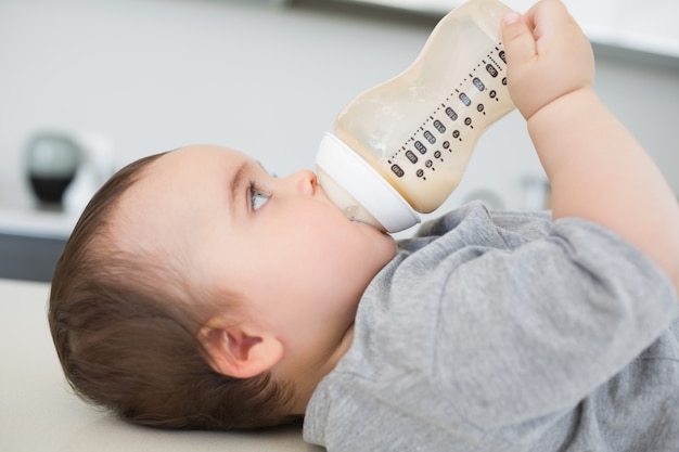 Bebê bebendo leite enquanto está deitado no balcão
