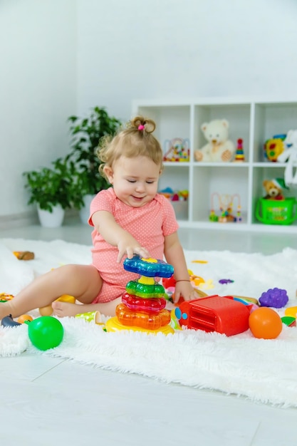 Bebê brinca com brinquedos em seu quarto Foco seletivo Criança