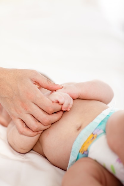 Foto bebê brincando com a mão de sua mãe