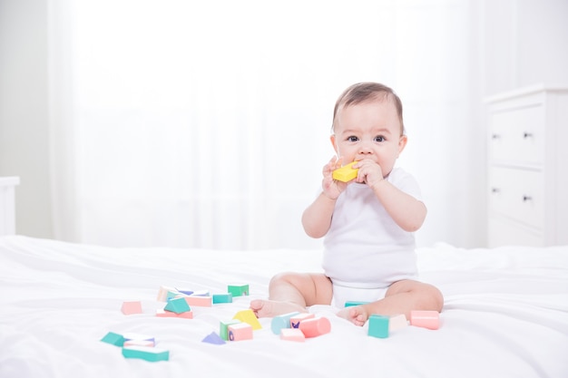 Bebê brincando com blocos na cama