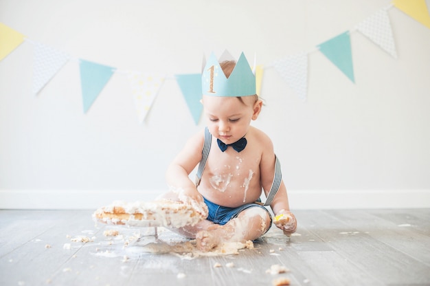 Bebê brincando com um bolo durante a sua festa de aniversário do bolo smash