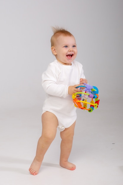 Bebê brincando de brinquedo colorido isolado em um fundo branco