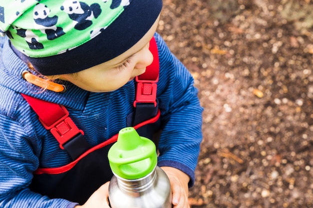 Foto bebê brincando em um caminho da floresta no outono