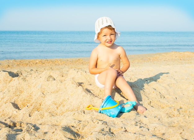 Bebê brincando na praia perto do mar