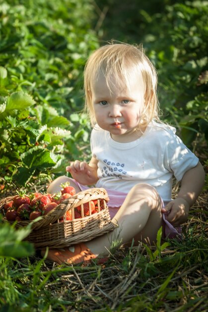 Bebé en campo de fresas