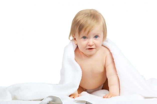 Bebé caucásico cubierto con la toalla aislada en el fondo blanco