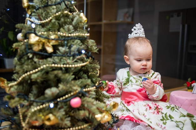 Bebé cerca del árbol de año nuevo