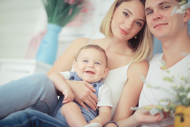 bebê com os pais em uma casa aconchegante / jovem família saudável mãe pai e bebê, sorriso de felicidade