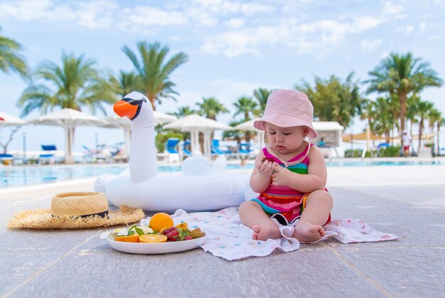 El bebé come fruta de vacaciones. Comida.