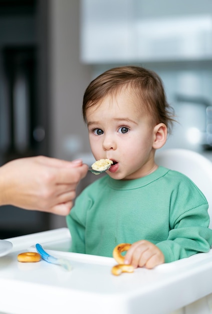 Bebé comiendo comida en la cocina