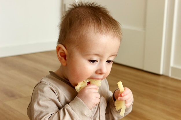 Foto un bebé está comiendo un plátano y tiene un plátana en la boca