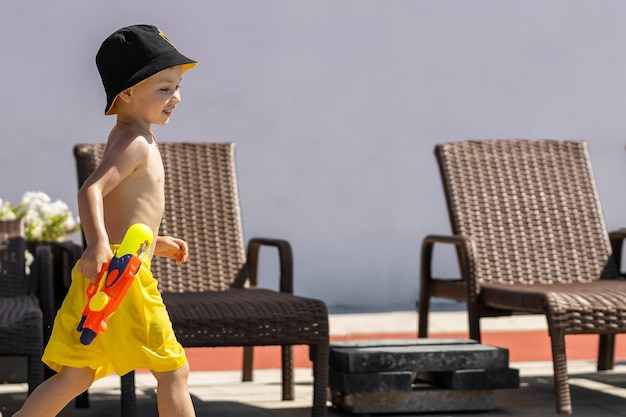 Foto el bebé corre y juega en la zona de la piscina en verano