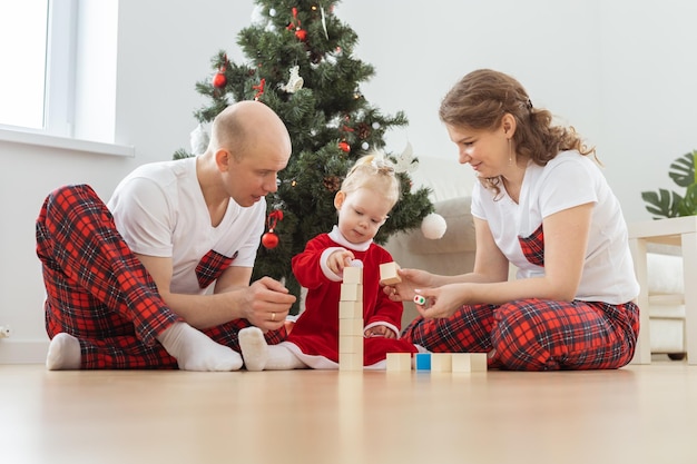 Bebê criança com aparelho auditivo e implante coclear se divertindo com os pais na sala de natal diversidade surda e saúde e diversidade