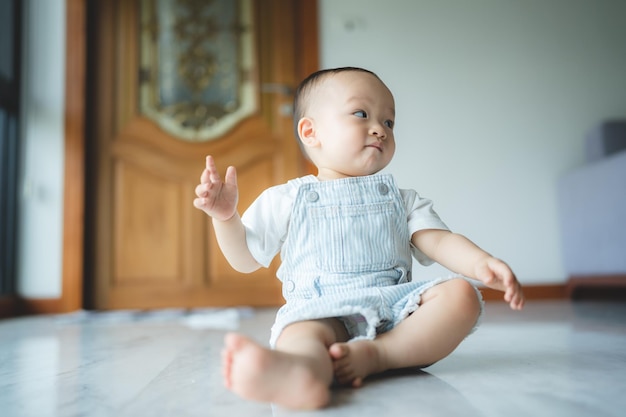 Bebê criança ou criança aprendendo a andar no chão com um sentimento de diversão feliz em casa garotinho pequeno é um passo saudável no estilo de vida da infância apoio da família