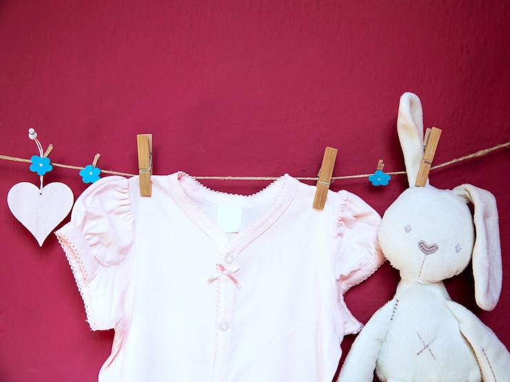 Foto bebê criança roupas, mercadorias e brinquedos pendurados em prendedores de roupa no varal no fundo da parede