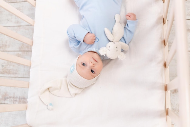 Bebé en la cuna en casa por la mañana o antes de ir a la cama retrato familia y concepto de nacimiento