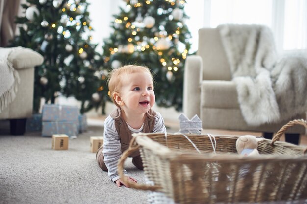 Bebê de 1 ano rastejando no chão em casa.