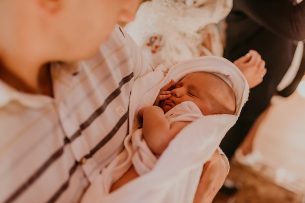 Bebê de mãos dadas com o padrinho. rito do sacramento da epifania na igreja