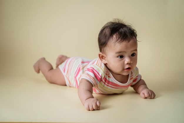 Bebê deitado de barriga no estúdio