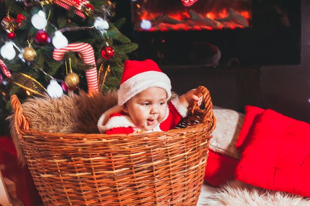 Bebé disfrazado de Santa juega en adornos navideños