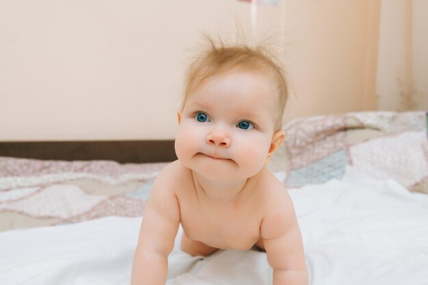 Un bebé divertido gateando en la guardería en casa el bebé tiene 6 meses aprendiendo a gatear