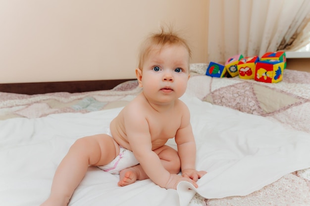 Un bebé divertido gateando en la guardería en casa el bebé tiene 6 meses aprendiendo a gatear