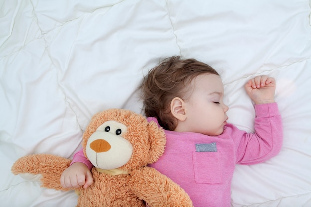 Bebê dorme com um urso de brinquedo