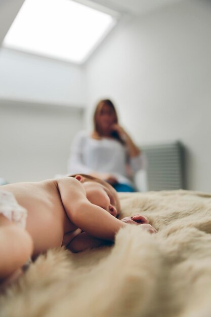 Bebê dormindo em um cobertor enquanto sua mãe olha