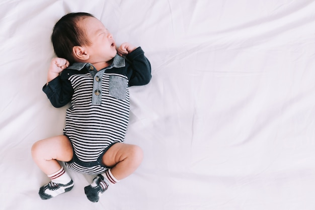 Bebê dormindo na cama branca macia no quarto - momentos felizes em família