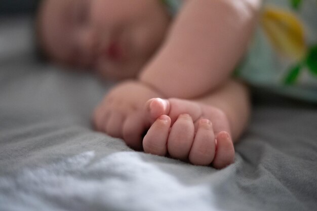 Foto bebê dormindo pacificamente com foco seletivo na mão